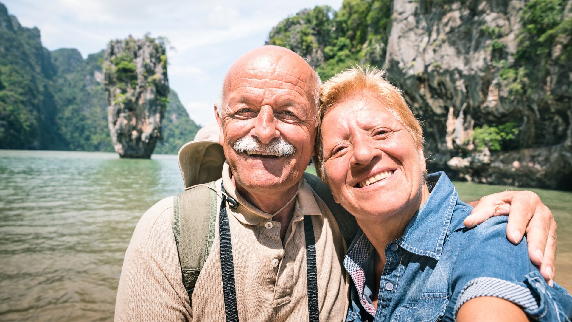 older couple taking a selfie in front of a beautiful landscape