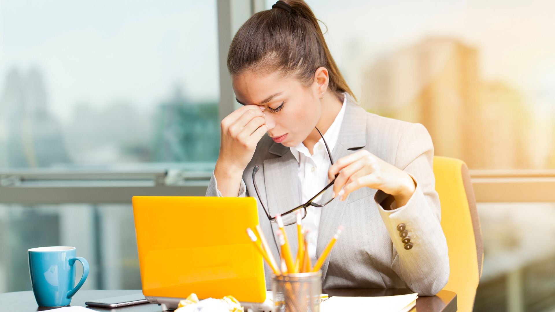 woman sat at her office desk looking stressed